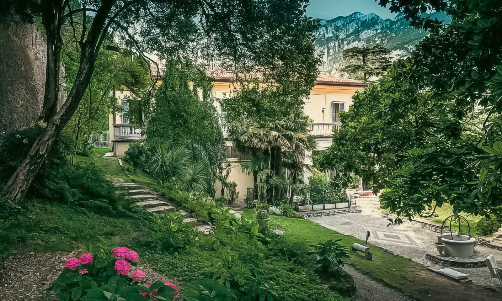 A serene garden with lush greenery, stone pathways, and a charming villa backdrop, framed by mountains under a clear sky.